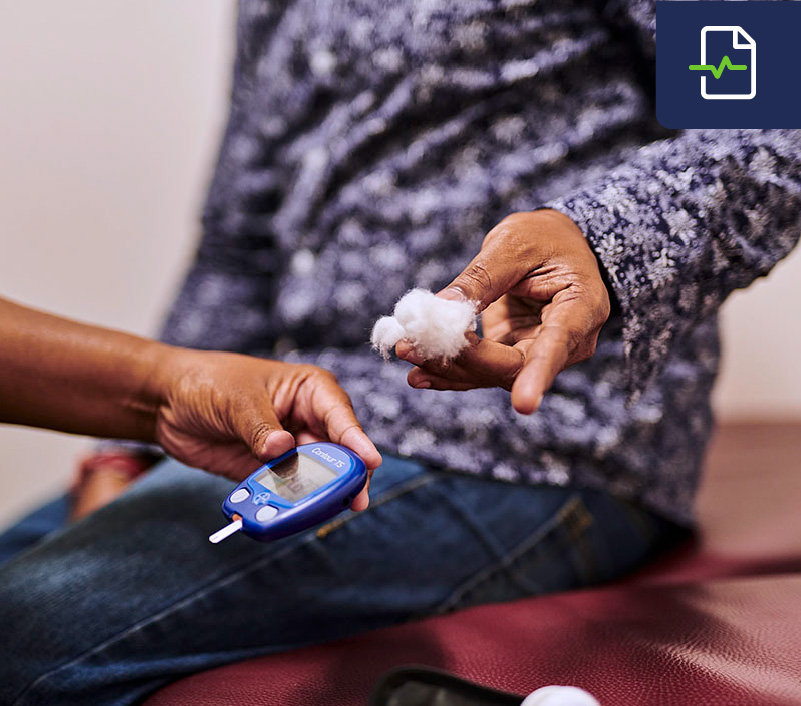 A nurse checking a patient's blood glucose/sugar level using a glucometer