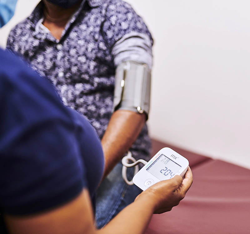 Nurse reading the blood pressure of a patient using a Sphygmomanometer.